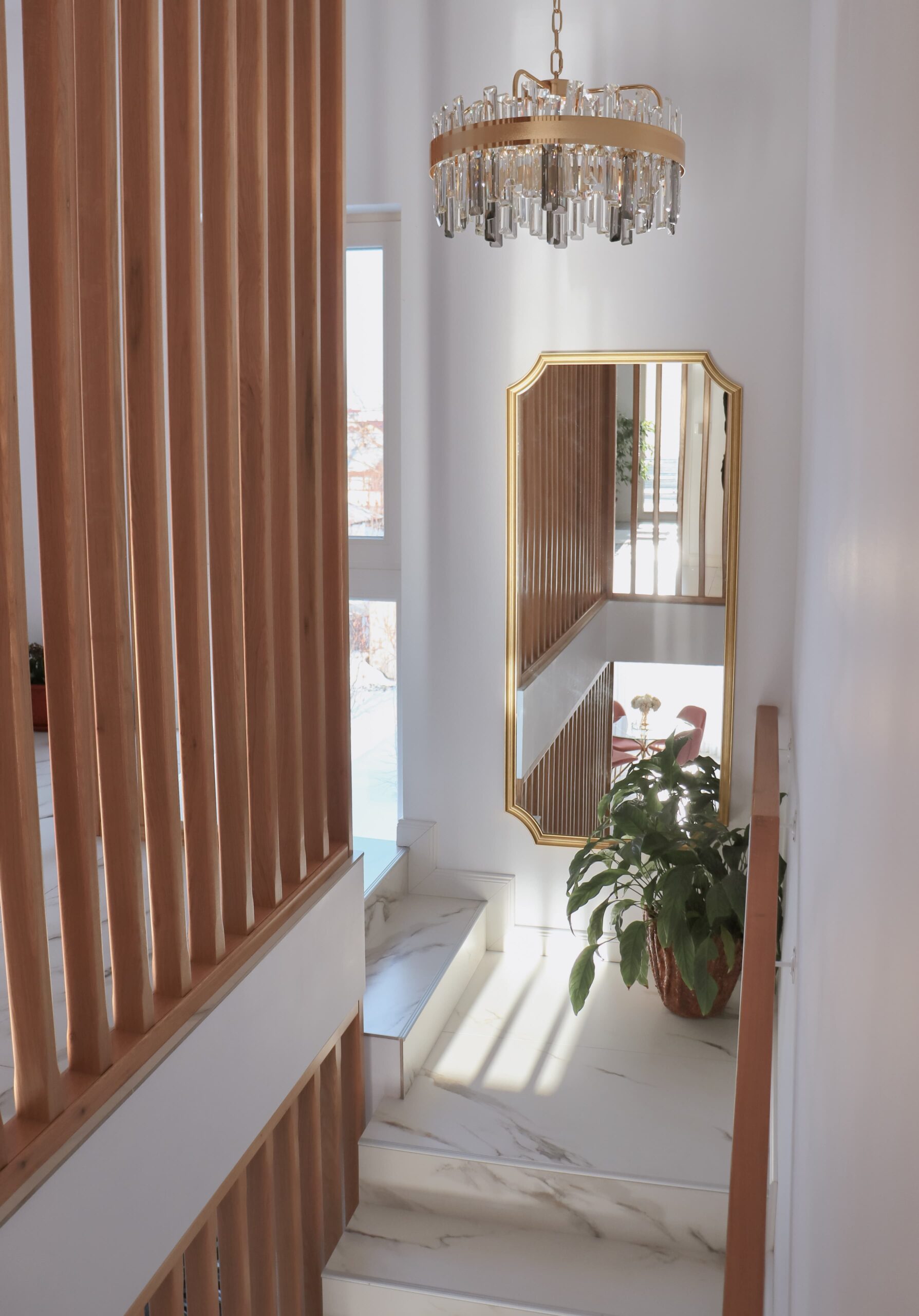 Decorul elegant este continuat prin oglinda supradimensionată și candelabrul auriu