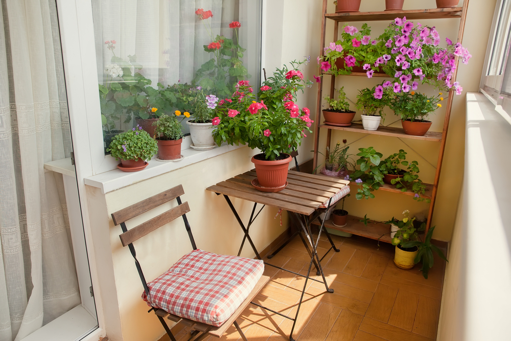 balcon amenajat pentru a fi un colț de relaxare cu plante și scaune cu masă