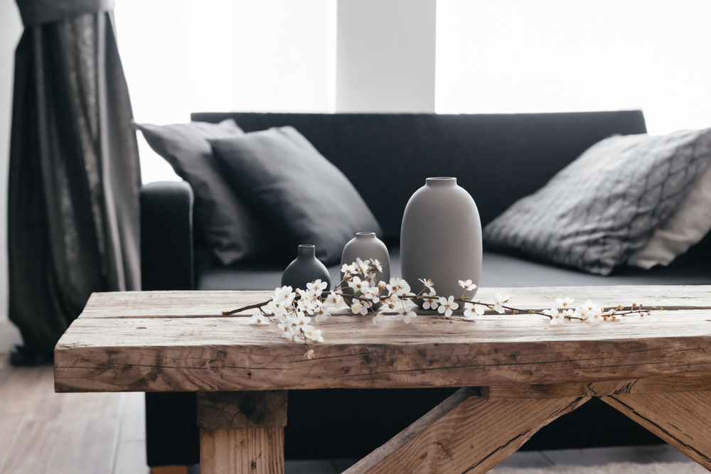 masa din lemn masiv pe post de decor rustic la interior cu o creanga inflorita