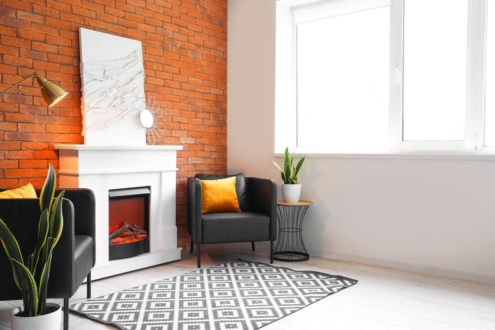 semineu electric incastrat in panouri decorative albe in living cu covor, fotoliu si geamuri