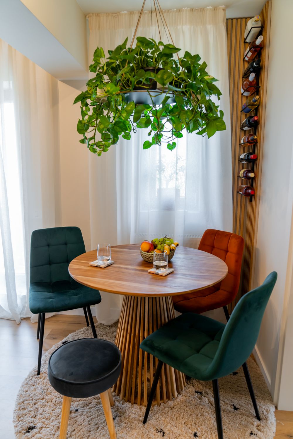 zona de dining din bucatarie masa rotunda candelabru diy cu plante scaune din catifea albastru portocaliu