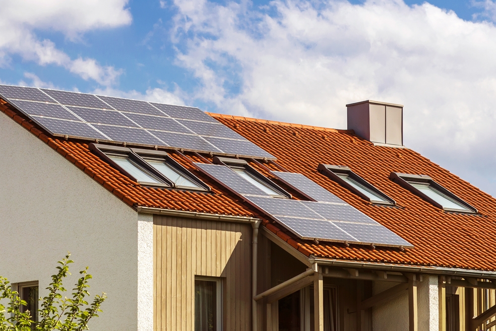 panouri solare pe casa pe acoperis rosu vedere cer albastru