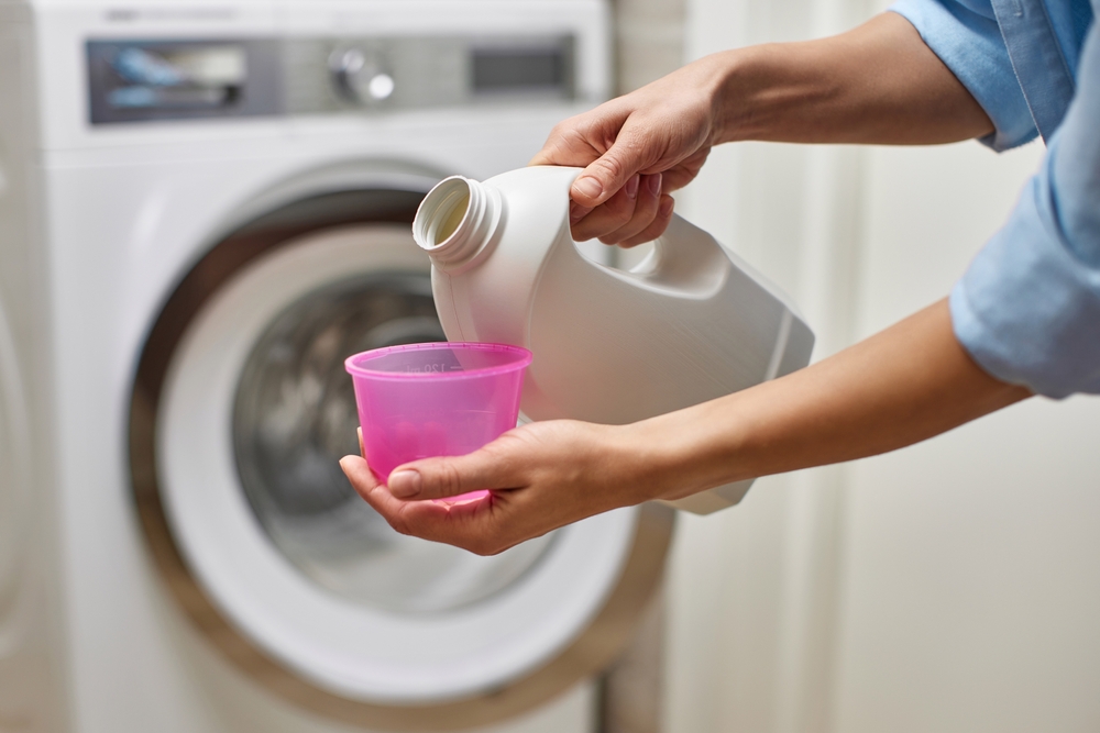 detergent masina de spalat haine in cupa turnat de femeie