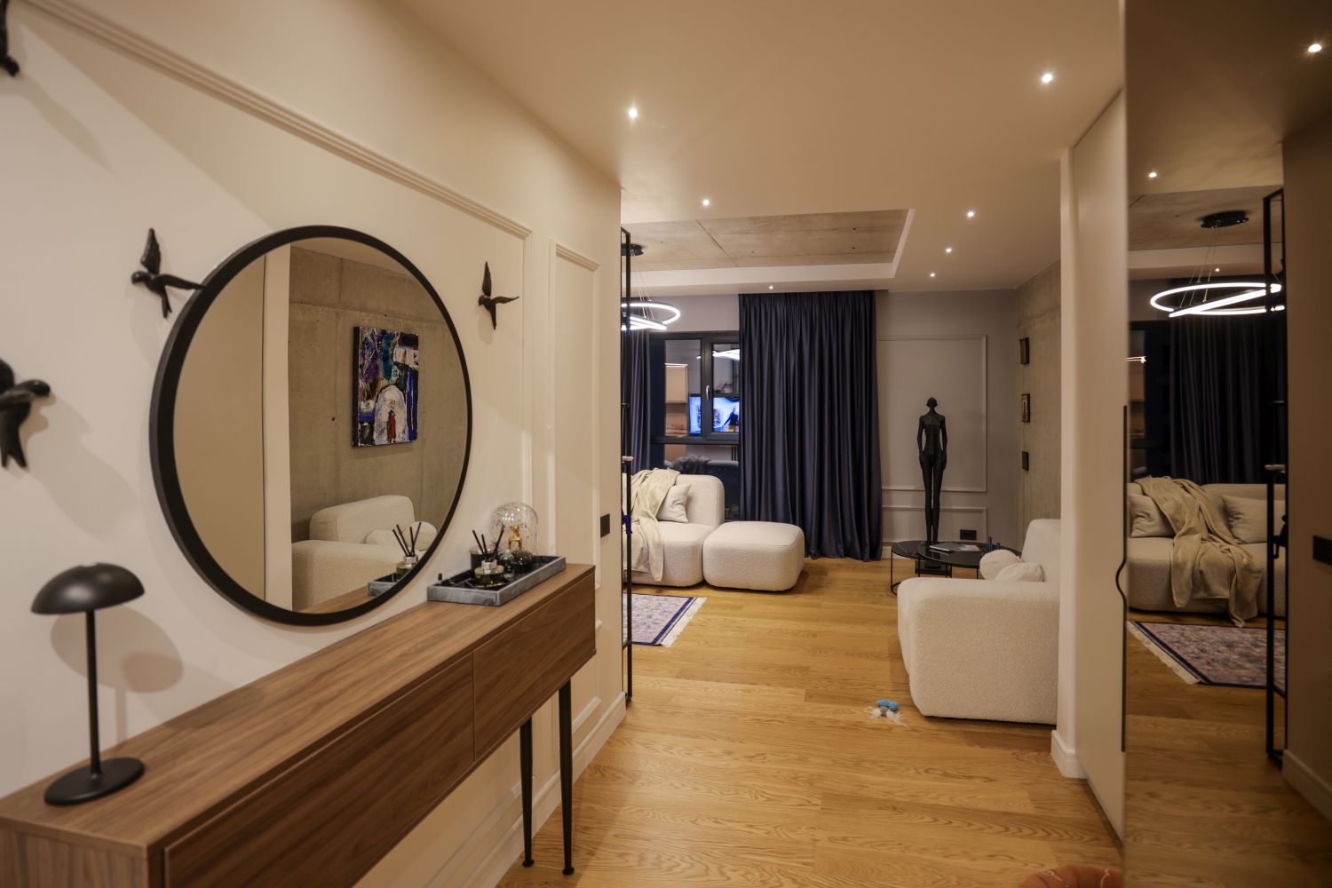 amenajare open space apartament andra marinescu de la visuri la cheie cu parchet din lemn beton aparent si canapea alba vedere din hol catre living