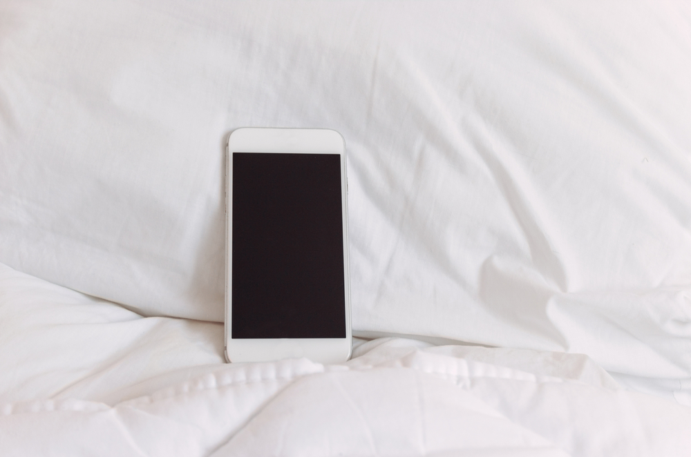 telefon smart pe perna in pat