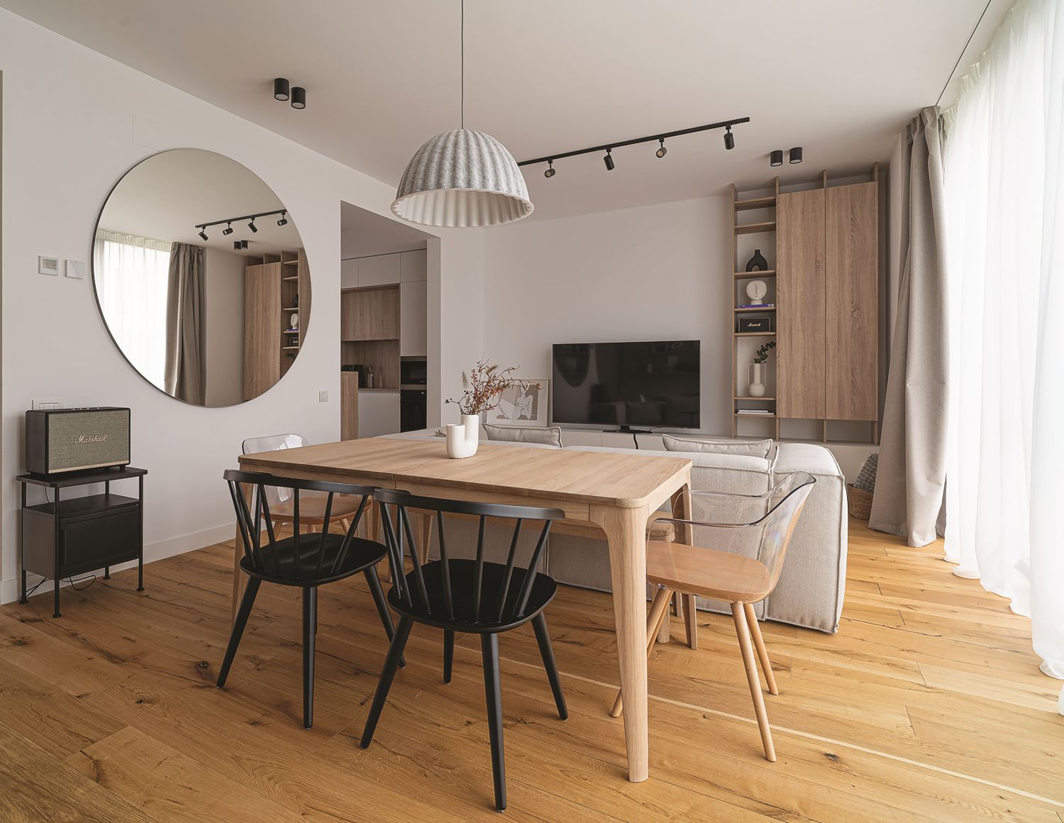 amenajare casa living dining open space parchet lemn masa cu scaune negre oglinda rotunda biblioteca