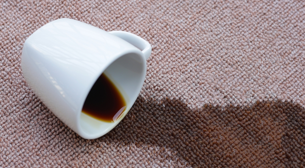 cana de cafea varsata pe covor